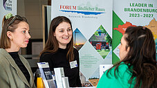 Drei Frauen im Gespräch am Stand des Forum Ländlicher Raum Brandenburg